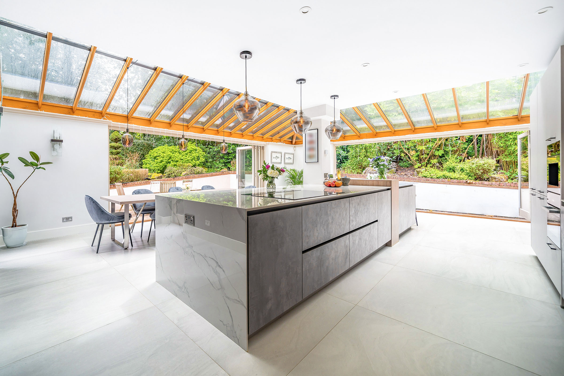 a modern kitchen extension with grey kitchen island and bifold patio doors