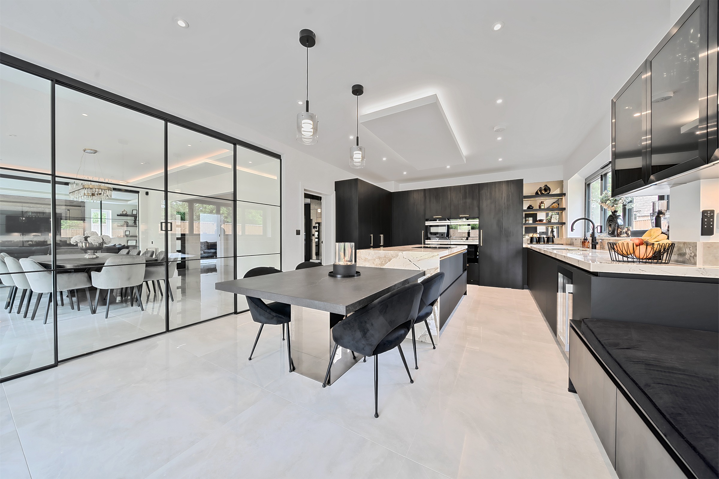Black modern kitchen with mirrored pillar, bench seating and glass details