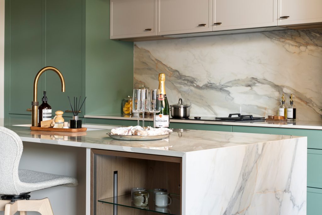 Flat Green modern trade kitchen by KCA featuring marble-effect quartz island with mitred waterfall edge, brass Quooker tap and luxury detailing — showcasing contemporary German craftsmanship and precision design for developers.