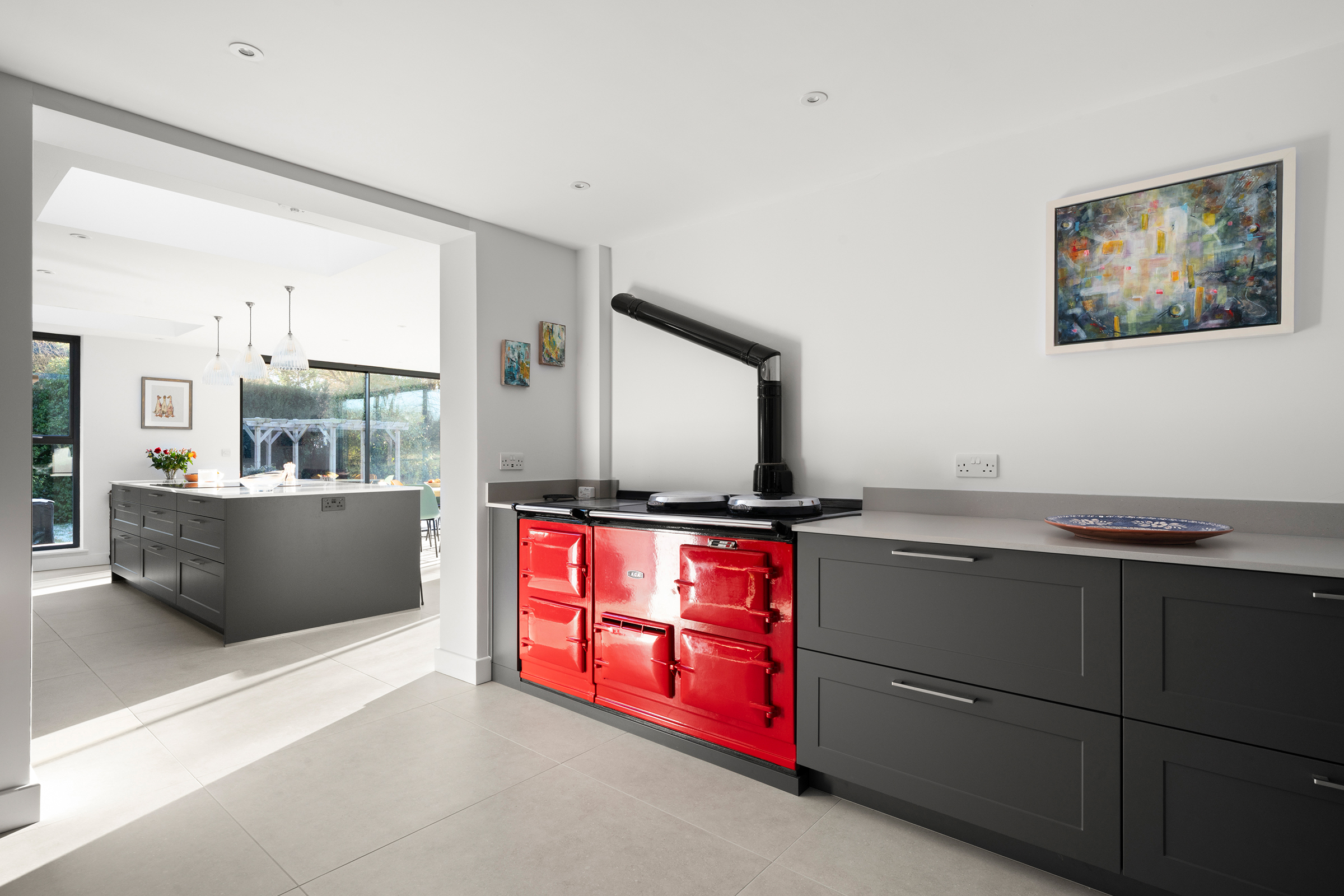 A vibrant red Aga in a modern dark grey shaker kitchen design.
