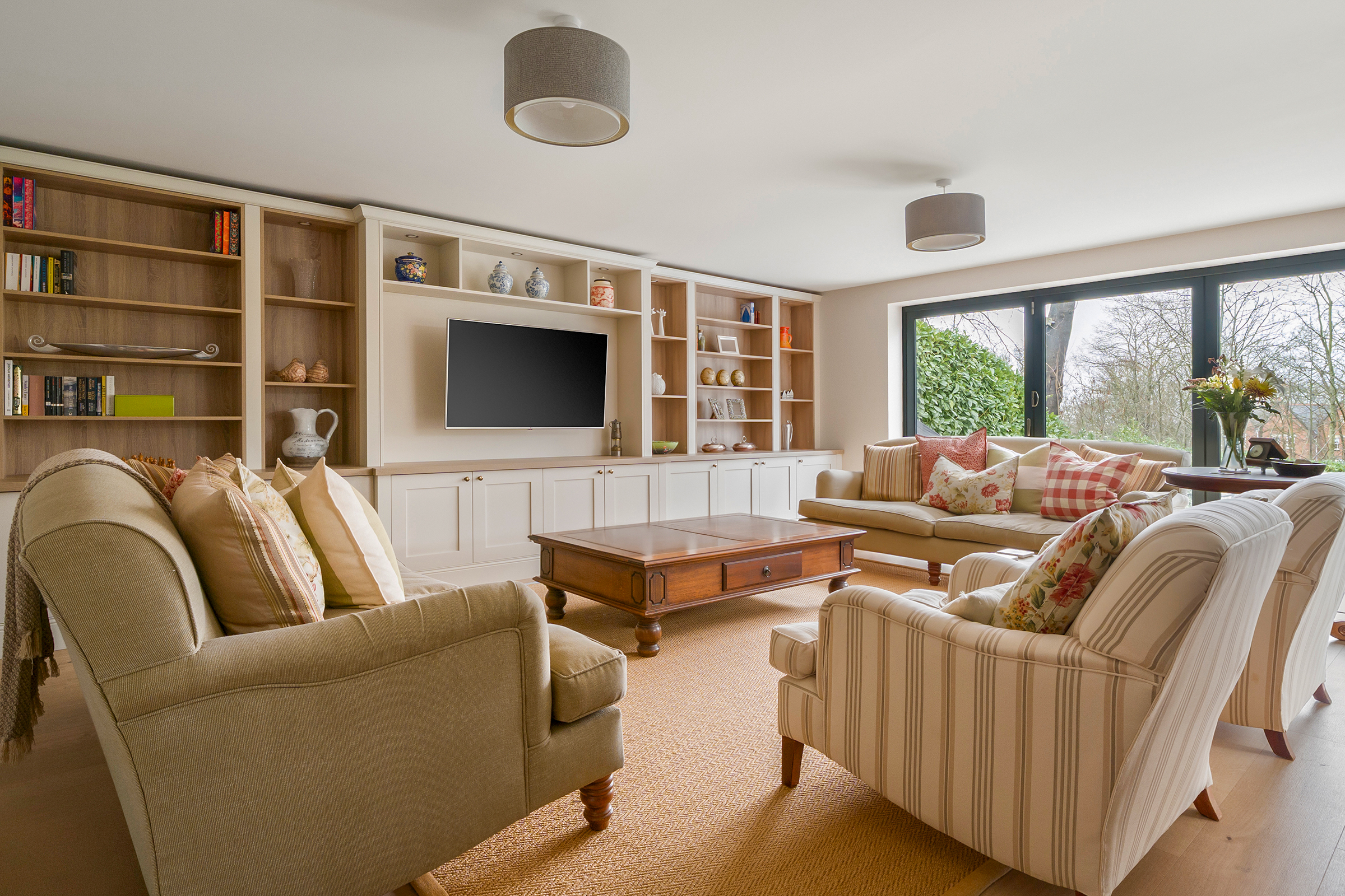 Living room with traditional fitted furniture with media area , storage and bookcases