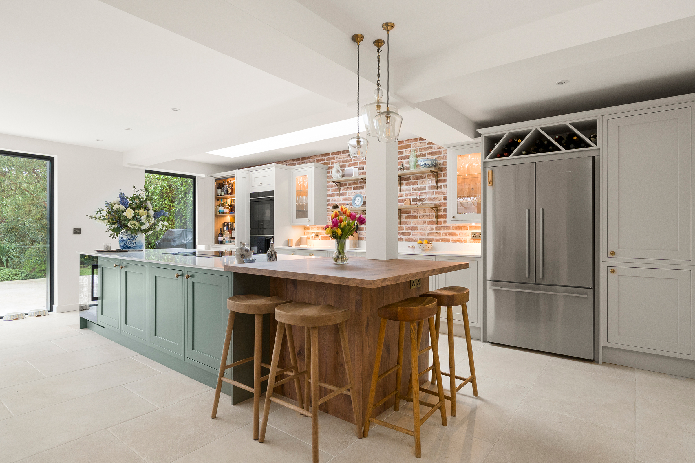 A Modern Botanical Green Shaker Island with Oak Breakfast Bar Seating as Part of a Home Extension