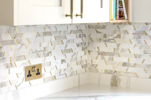 Gold and white marble tiles in a kitchen design.